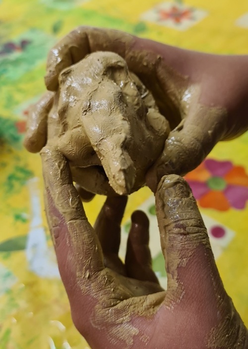 Kinderhände die nassen Ton formen