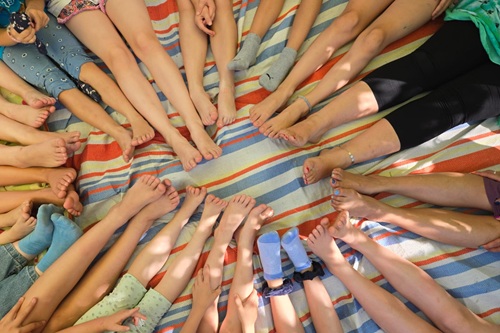 Füße und Beine liegen in einem Kreis auf einer bunten Decke